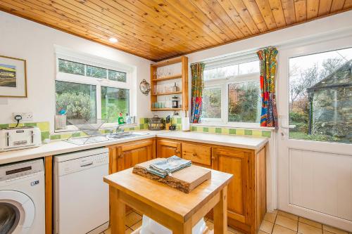 a kitchen with a sink and a washer and dryer at 1 Caerau Isaf in Haverfordwest