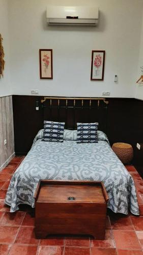 a bedroom with a large bed with a wooden table at APARTAMENTO La CAVA in Guadalcanal