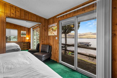 a bedroom with a bed and a view of a lake at The Meadowlark Cabin in Big Arm