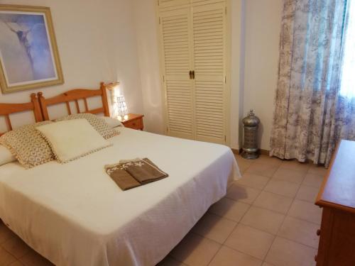 a bedroom with a white bed with a tray on it at Deltamar Solo Familias Serviplaya in Xeraco