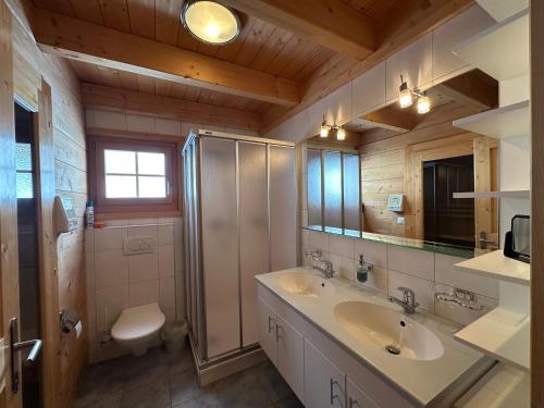 a bathroom with two sinks and a shower and a toilet at Chalet Allegra AL0 in Belalp