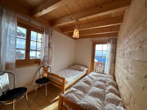 a bedroom with a bed and a table and chairs at Chalet Allegra AL0 in Belalp