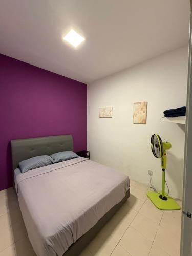 a bedroom with a bed and a purple wall at The Cave - Adults Only in Tanah Rata