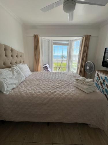 a bedroom with a large bed with a window at Ocean Front Condo - 3 Bdrms - Hot Tubs - 2 Pools - Gym - Tennis ct - SS2203 in Galveston