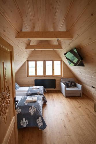 a attic room with two beds and a couch at Pikno Chata PL in Biały Dunajec