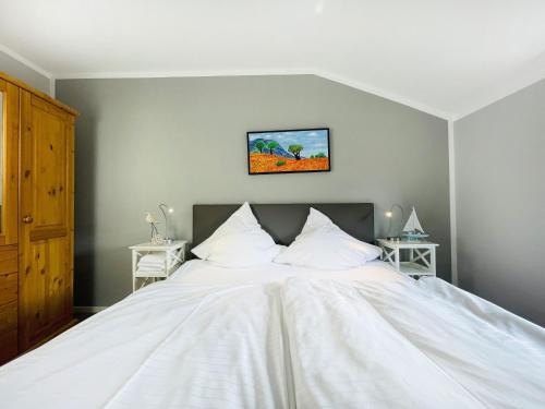 a bedroom with a large white bed with two night stands at Apartment Rickmer Rickmers Teichhof Fehmarn in Wenkendorf