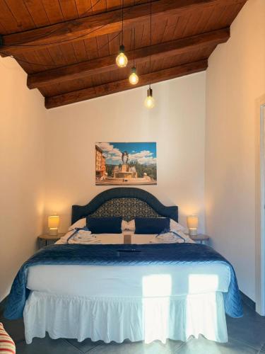 a bedroom with a large bed with two lamps at MECE Rooms in LʼAquila