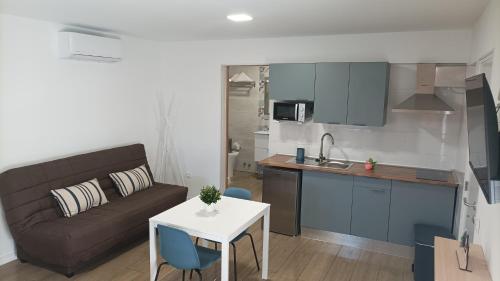 a kitchen and a living room with a couch and a table at Casa Senderos del Norte in Sauzal