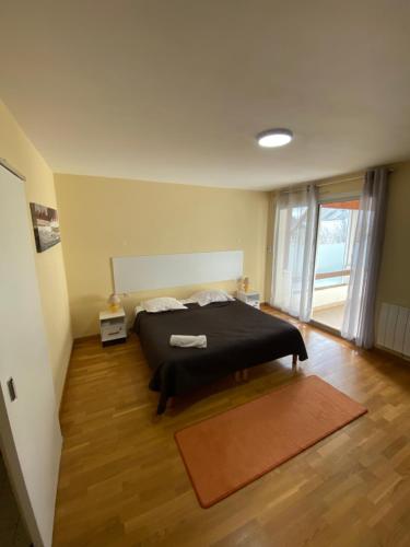 a bedroom with a black bed and a wooden floor at Gîte 4 Le Cerizay - proche du PuyduFou in Cerizay