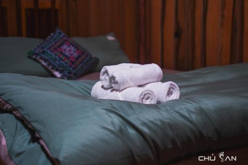 a pile of towels sitting on top of a bed at San's House in Hữu Lũng