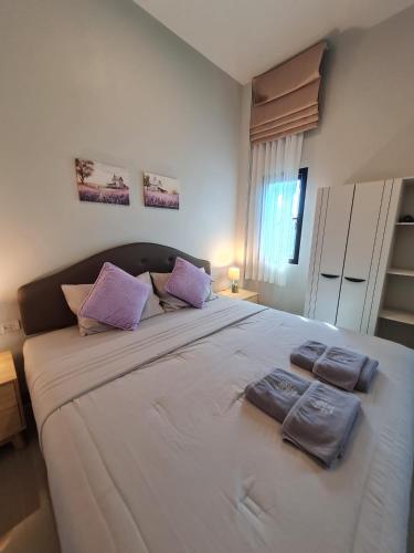 a large bed in a bedroom with purple pillows on it at Samati Hill - Pool Villa H2- Klong Ning Beach in Ko Lanta Yai