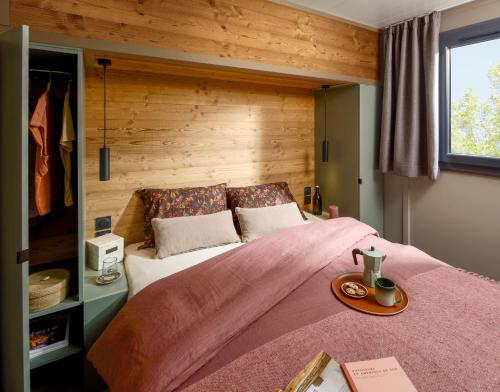 a bedroom with a large bed with a wooden wall at U Pinarellu in Zonza