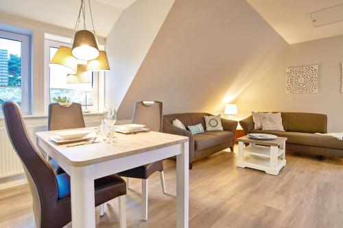 a living room with a table and a couch at Südstern OG, Schwalbenweg in Wyk auf Föhr