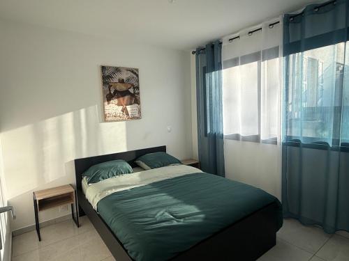 a bedroom with a bed with green sheets and a window at Maison centre-ville in Dijon