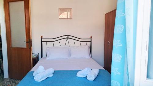 a bed with two white towels on top of it at Dimitreli Beach House in Telendos