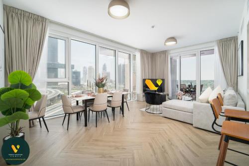 a living room with a couch and a table and chairs at Vogue Vacation Homes, Al Wasl 1 Residences Near Zabeel Park and World Trade Centre, Two Bedroom Apartment with Balcony and City View, Access to all Amenities, Walkable to Max Fashion Metro Station in Dubai