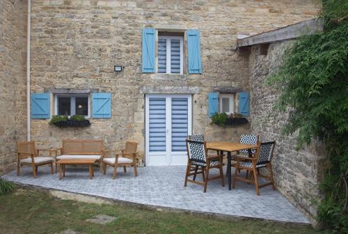 a patio with tables and chairs in front of a building at La Bonne Vie Gite in Chaunay