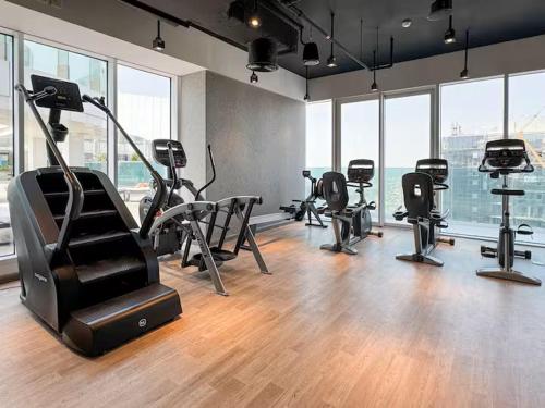 a gym with treadmills and ellipticals in a room with windows at Vogue Vacation Homes, Al Wasl 1 Residences Near Zabeel Park and World Trade Centre, Two Bedroom Apartment with Balcony and City View, Access to all Amenities, Walkable to Max Fashion Metro Station in Dubai
