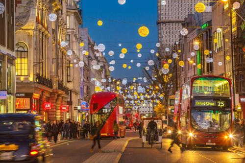 a busy city street with double decker buses and people at Moxy London Piccadilly Circus in London