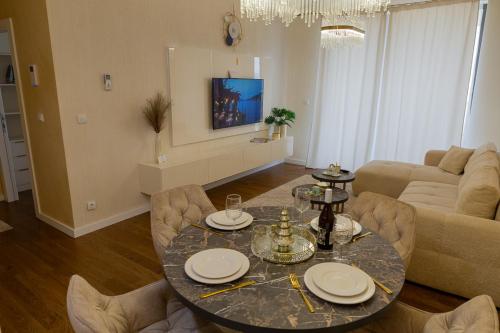 a living room with a table and a couch at Premium Planet Deluxe & SPA in Niš