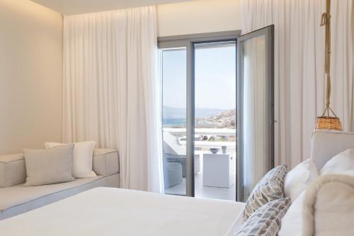 a bedroom with a bed and a sliding glass door at 18 Grapes Hotel in Agios Prokopios