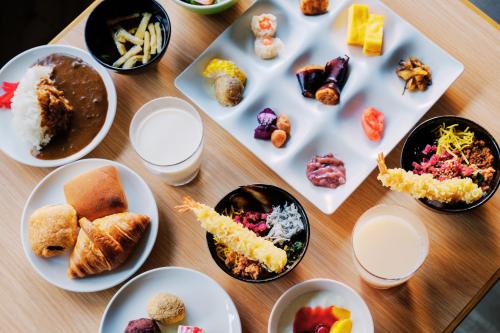 a wooden table with plates of food on it at Smile Hotel Premium Hakodate Goryokaku in Hakodate