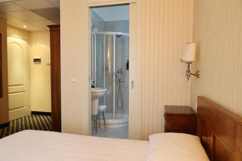 a bedroom with a bed and a bathroom with a shower at Hotel Ristorante Ca' Nova in Marghera