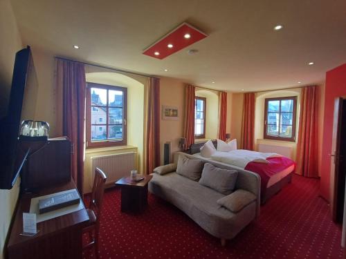a hotel room with a bed and a couch at Landhotel Thürmchen in Schirgiswalde