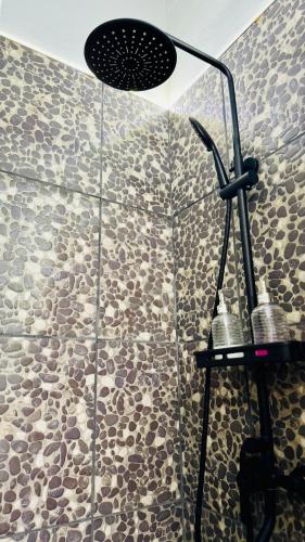 a shower in a bathroom with a stone wall at Monoambiente Eldorado 1 in Eldorado