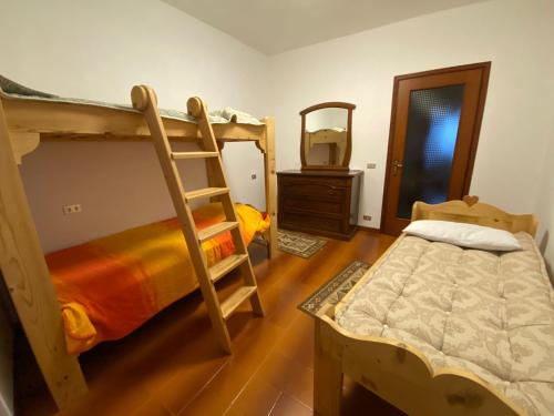a bedroom with two bunk beds and a mirror at Dormire a Valgoglio Baita della Diga in Valgoglio