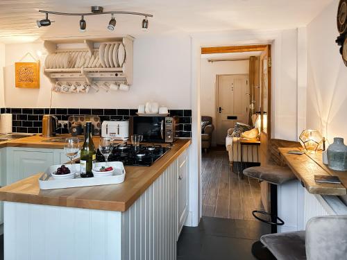 a kitchen with a counter top with a bottle of wine at Time Cottage in Coltishall