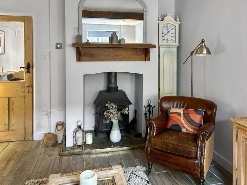 a living room with a chair and a fireplace at Time Cottage in Coltishall
