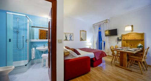 a bedroom with a bed and a table and a bathroom at Villaggio Turistico Ploner in Carbonin