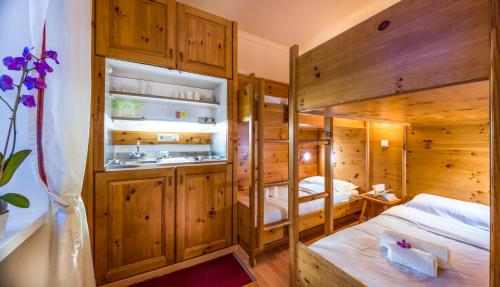 a bedroom with a bunk bed and a sink at Villaggio Turistico Ploner in Carbonin