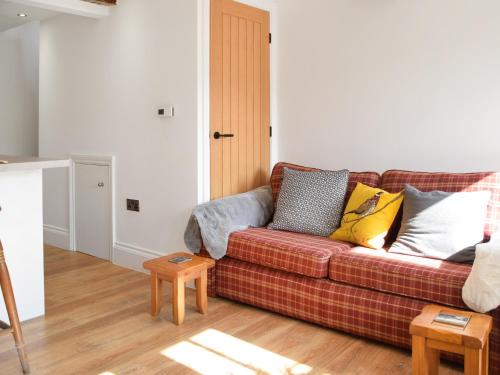 a living room with a couch with pillows on it at Kestrel Cottage in Holmfirth