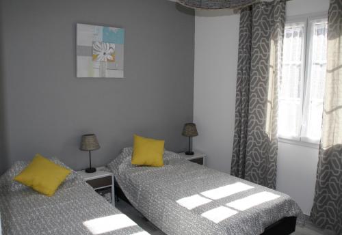 SeigyにあるGîte de Roches Hibouのベッドルーム1室(黄色い枕のベッド2台付)