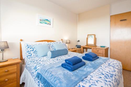 a bedroom with a bed with blue pillows on it at Ty Peggie in Haverfordwest