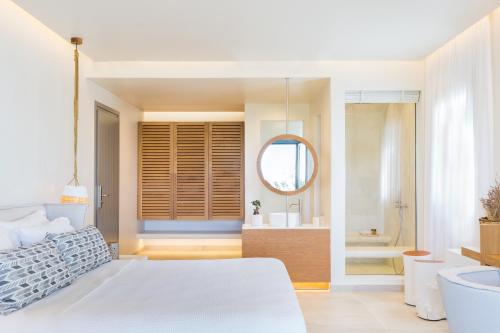 a bedroom with a large bed and a bathroom at 18 Grapes Hotel in Agios Prokopios