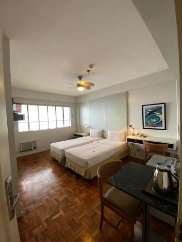 a bedroom with a large bed and a table at The Clipper Hotel Makati in Manila