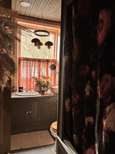 a bathroom with a sink and a toilet and a window at The Goose Garden in Hebden Bridge