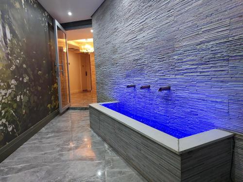 a bathroom with a large tub with blue water at Umhlanga Apart Hotel in Durban