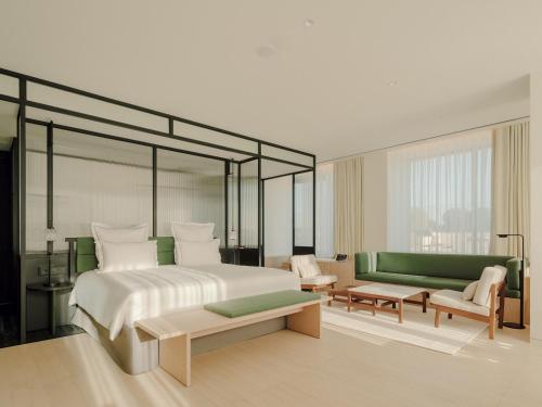 a bedroom with a large bed and a green couch at The Telegraph Hotel - The Leading Hotels of the World in Tbilisi City