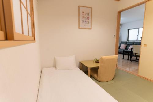 a small room with a bed and a chair at Naha Airport NewVilla 4 bedrooms, 2 modern bathrooms, 3 FREE parking in Itoman