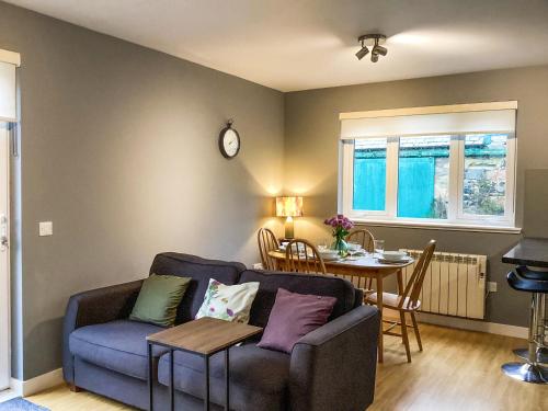 a living room with a couch and a table at Uppermill Farm in Tarves