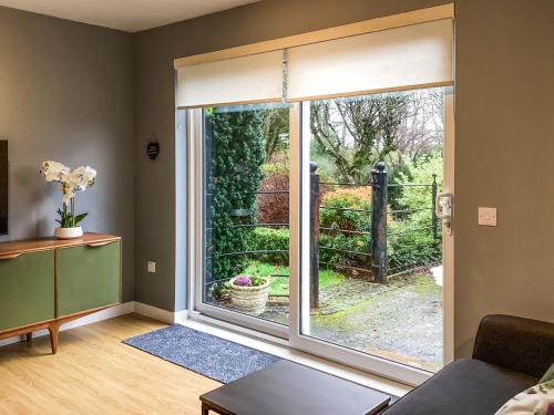 a living room with a window with a view of a garden at Uppermill Farm in Tarves
