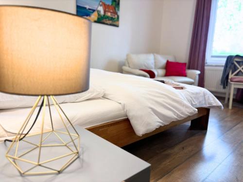 a bedroom with a bed and a table with a lamp at Jutta vom Kutter in Wulfen auf Fehmarn