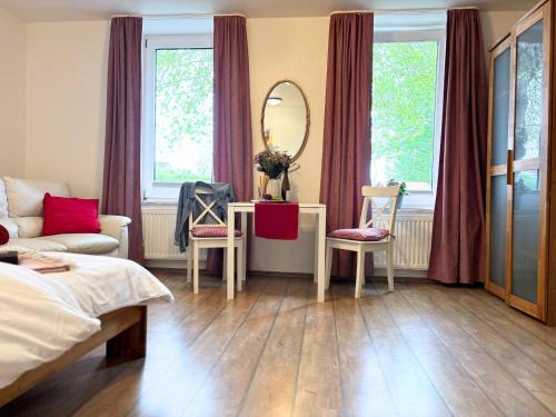 a bedroom with a bed and a table and a mirror at Jutta vom Kutter in Wulfen auf Fehmarn