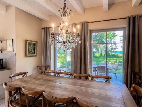a dining room with a wooden table and a chandelier at Ferienhaus Libelle - Feriendomizil für 14 Pers - Haupt- und Nebenhaus in Rankwitz