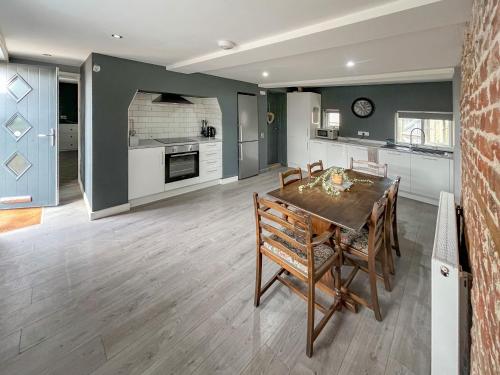 a kitchen and dining room with a table and chairs at Forge Cottage in Canterbury