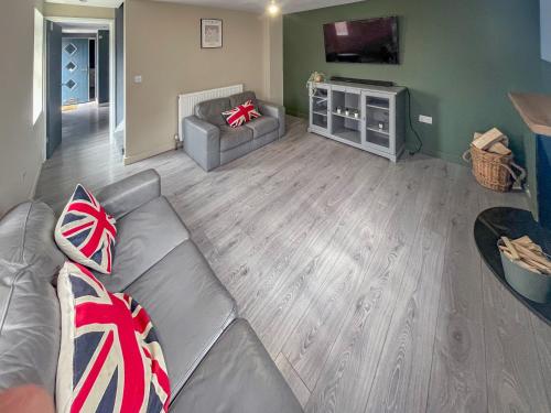 a living room with a couch and a tv at Forge Cottage in Canterbury